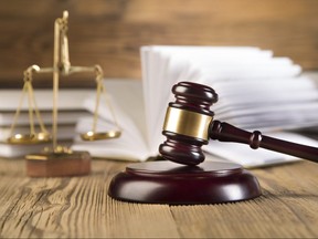 Golden scales of justice, gavel and books wood brown background