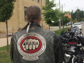 A member of Bikers Against Child Abuse stands with some of the motorbikes used o escort a young girl to Superior Court where she testified against the former common-law partner of her mother in a sexual assault trial. BACA works to protect abused children from further abuse and support them through trial procedures.