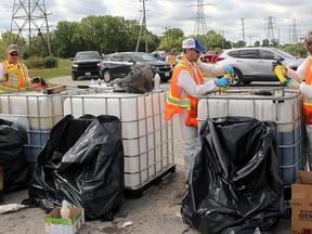 This is a file photo of a past annual Chatham-Kent Household Hazardous Waste Day. Vehicles were lined up to get into the public works yard on Creek Road in Chatham to drop off various oils, solvents and other hazardous materials. Pictured from left, Drew Watts, Tyler Hiller and Dave Better were busy disposing of unwanted oil products. The event was also held at the Chatham Township and Tilbury public works garages. (Elwood Shreve/Chatham Daily News)