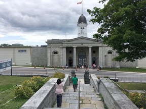A couple takes photos in front of Kingston Penitentiary.