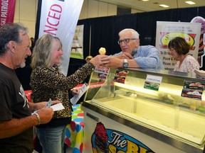 Richard and Ruth Kneider of Simple Dreams Ministries served up a scoop of roasted garlic ice cream, made special each year by Renee's Bistro in Stratford, to Susan Jane and Larry Distefano at the Stratford Kiwanis Garlic Festival Saturday afternoon. Galen Simmons/The Beacon Herald/Postmedia Network