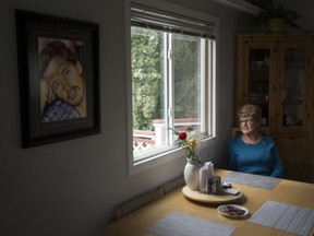 Jane Orydzuk, Victims of Homicide Support Society president and founder, sits at her kitchen table while speaking to a reporter, in Edmonton Friday Sept. 6, 2019. A portrait of her son Tim Orydzuk is visible on the wall nearby. Tim Orydzuk was murdered Oct. 1, 1994. Photo by David Bloom