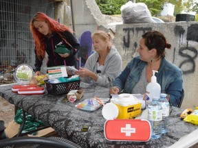 STOP (Sudbury Temporary Overdose Prevention) Society volunteers Carla Ocampo, left, Kathy Savage and Karla Ghartey, a registered nurse and one of the group's founding members, arrange supplies at an overdose prevention site off Lloyd Street in 2019.