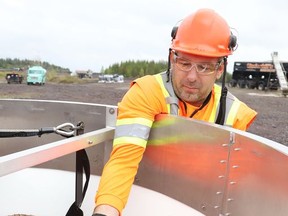 Dan Haupt, of Zimmer Air Services Inc., shows a fertilizer mixture that is being used in Vale's annual aerial seeding program in this file photo. The program targets barren land requiring reclamation around the company's operations.