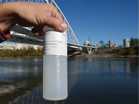 A technician from Alberta Environment and Parks holds a water sample from the North Saskatchewan River by the Walterdale Bridge on Thursday, Oct. 3, 2019. ED KAISER / POSTMEDIA