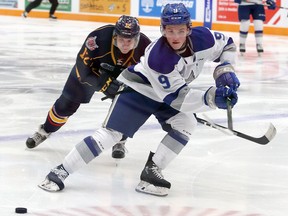 Sudbury Wolves forward Landon McCallum (9) dumps a puck into the offensive zone while Barrie Colts forward Matej Pekar (12) gives chase during first-period OHL action at Sudbury Community Arena in Sudbury, Ontario on Friday, October 18, 2019.
