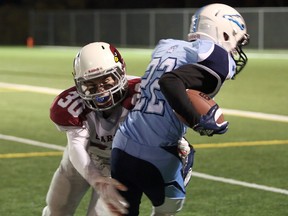 Brennan Maag (22) of the St. Benedic Bears is tackled by Aidan Teeter (30) of the St. Charles Cardinals during SDSSAA senior boys football championship action at James Jerome Sports Complex in Sudbury, Ontario on Friday, October 25, 2019.