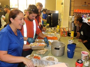 Entegrus employees  Sarah Regnier, front, corporate communication specialist, Kyle Parry, a power line technician, and Gerry Lankhof, senior financial analyst, are seen here serving Thanksgiving dinner during the annual Entegrus Thanksgiving luncheon in October 2019. (Ellwood Shreve/Chatham Daily News)