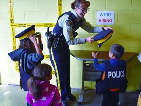 Sgt. Jolene Nason lets some local kids try on police hats during an open house at the Devon RCMP detachment in 2019.
(Emily Jansen)