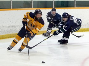 Laurentian Voyageurs defender Jaimee MacDonald (8) looks to carry the puck up ice while a pair of Nipissing Lakers give chase during OUA women's hockey action at Gerry McCrory Countryside Sports Complex in Sudbury, Ontario on Thursday, October 17, 2019.