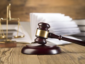 Golden scales of justice, gavel and books wood brown background