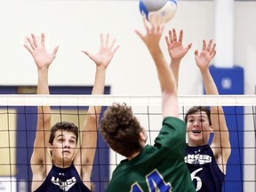 Ursuline Lancers' Brent Nevills (9) and Zack Myers (6) try to block Sam Demmings (14) of the St. Patrick's Fighting Irish during an LKSSAA 'AAA' senior boys' volleyball semifinal at Ursuline College Chatham in Chatham, Ont., on Tuesday, Nov. 5, 2019. Mark Malone/Chatham Daily News/Postmedia Network