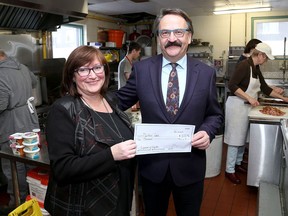 Lubomyr Luciuk presents a cheque to Ronda Candy of Martha's Table at the 2019 Judgement of Kingston wine-tasting competition. (Ian MacAlpine/The Whig-Standard)