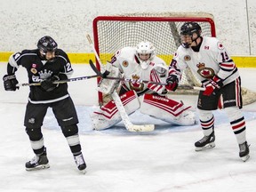 Sarnia Legionnaires goalie Nolan DeKoning watches Legionnaires' Drayton Todoroff (19) battle Komoka Kings' Jacob Rochford (24) at Sarnia Arena in Sarnia, Ont., on Thursday, Nov. 21, 2019. (Shawna Lavoie Photography)