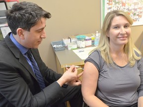 Grey-Bruce Medical Officer of Health Dr. Ian Arra giave Sarah Ellis, manager of the vaccine preventable diseases program, her flu shot at the Grey Bruce Health Unit Oct. 30, 2019, in Owen Sound. Rob Gowan/Postmedia Network