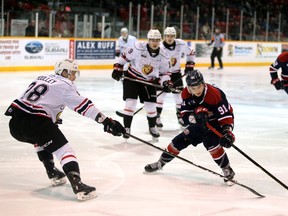 Saginaw Spirit centre Cole Perfetti drives the puck wide on Owen Sound Attack defender Mark Woolley as the Attack host the Spirit inside the Harry Lumley Bayshore Community Centre Saturday.