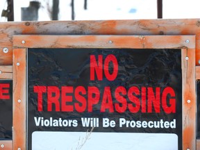 A warning sign is posted on a fence at the entrance to a rural property north of Okotoks, Alberta, south of Calgary on Tuesday, February 27, 2018.