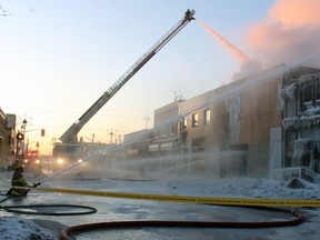 North Bay firefighters spray down Literacy Nipissing and two adjoining buildings in a 2019 fire. City council will vote on whether to support a staff report to spend $1.6 million on a new aerial tandem fire truck.