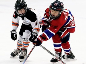 Kent Cobras' Ethan Lenover, left, and Belle River Jr. Canadiens' Chase Patterson battle for the puck during a minor atom 'AA' game at the annual Chatham Regional Silver Stick Tournament at Thames Campus Arena in Chatham, Ont., on Friday, Dec. 13, 2019. Mark Malone/Chatham Daily News/Postmedia Network