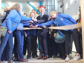 Mayor Jeff Genung helps members of the Cochrane Activettes officially open up the new large expansion of the Activettes's food bank. Patrick Gibson/Cochrane Times