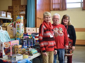 The Christmas Place, run under the umbrella of Operation Sharing, gives parents and kids a low-cost place to shop for Christmas presents. Pictured, from left, are volunteers Marilyn Schmiedl and Bill Writt, and co-ordinator Kathy Gardiner at College Avenue United Church, where donations of new gifts are still being accepted. (Kathleen Saylors/Woodstock Sentinel-Review)