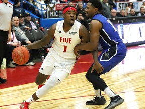 Jaylen Bland, left, of the Sudbury Five, drives to the basket during basketball action against KW Titans at the Sudbury Community Arena in Sudbury, Ont. on Thursday December 12, 2019.