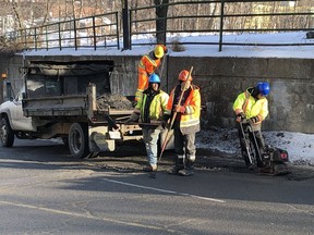 A contractor crew patches potholes near the College Street underpass in this file photo.