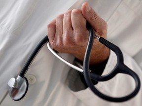 FILE PHOTO: A photo illustration shows a French general practitioner holding a stethoscope in a doctor's office in Bordeaux