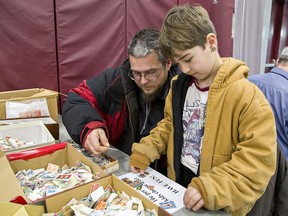 Justin Goodfellow of Simcoe and his eight-year-old son Raiden look through some boxes of stamps at the 2020 Brantford Stamp Club show.