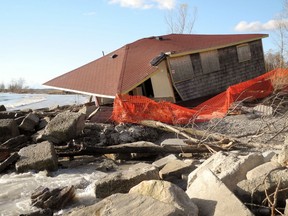 Safety fencing seals off the remains of a cottage, its south wall torn off during a windstorm, along Hastings Drive in Long Point where high Lake Erie water levels have dealt many cottages a beating.