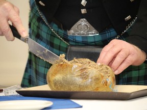 Angus Campbell cuts into the haggis at a Robbie Burns Supper at the Fort McMurray Legion in Fort McMurray, Alta. on Saturday, January 25, 2020. (Vincent McDermott/Postmedia Network)