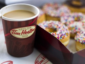 A cup of Tim Hortons Inc. coffee and doughnuts are arranged for a photograph in Toronto, Ontario, Canada, on Wednesday, Aug. 3, 2011. (Brent Lewin/Bloomberg)