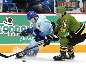 Chase Stillman, left, of the Sudbury Wolves, and Nick Grima, of the North Bay Battalion, battle for the puck during OHL action at the Sudbury Community Arena in Sudbury, Ont. on Friday January 10, 2020.