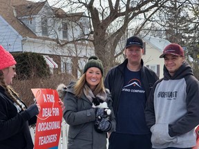 Shane Bogema (centre) and Julian Thibeault of The Roofing Company came to the rescue on Tuesday of a cat stuck in a tree on Erie Avenue. The distressed animal was noticed by elementary school teachers, including Emilie Holmes and Alysha Lombardi, who were picketing in front of the Grand Erie District School Board office during a one-day strike.