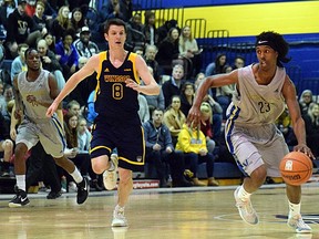 Haroun Mohamed (23) from the Laurentian Voyageurs handles the ball while Chris Poloniato of the Windsor Lancers tries to keep pace during OUA men's basketball action at the Ben Avery Gym in Sudbury, Ontario on Wednesday, February 19, 2020.
