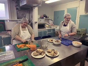 Lori Nason (left) and Ashby Stewart prepare ingredients for a pot of soup at The Raw Carrot in the kitchen of the Paris Presbyterian Church.