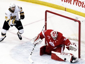 Sarnia Sting's Sean Josling, left, looks to pounce on a rebound before Soo Greyhounds goalie Nick Malik can cover up at GFL Memorial Gardens in Sault Ste. Marie, Ont. Peter Ruicci