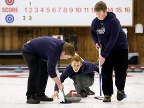 Ursuline Lancers' John Pumfrey, centre, watches his rock as Caden Rivard, left, and Austin Haddock sweep during the first draw against Carleton Place Notre Dame at the Ontario School Curling Provincial Championships at the Chatham Granite Club in Chatham, Ont., on Thursday, Feb. 13, 2020. Mark Malone/Chatham Daily News/Postmedia Network
