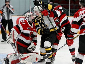 Kingston Frontenacs forward Jordan Frasca battles with Ottawa 67's payers for control of the puck in front of Ottawa goaltender Will Cranley.