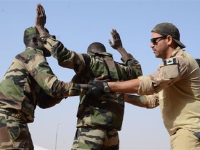 A Canadian Special Operations Regiment instructor teaches soldiers from the Niger Army how to properly search a detainee in Agadez, Niger, Feb. 24, 2014 during that year's Flintlock exercise. (U.S. Army photo)