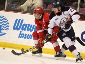 Soo Greyhounds winger Cole MacKay (left) and Saginaw Spirit's Reilly Webb battle along the boards during Ontario Hockey League action in Sault Ste. Marie  (BRIAN KELLY/THE SAULT STAR/POSTMEDIA NETWORK)