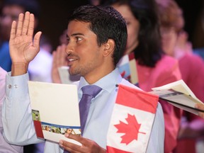 Lashan Munasinghe of Sri Lanka reads the oath to become a Canadian citizen  at the community citizenship ceremony at Science North in Sudbury, Ont. on Thursday August 17, 2017. New reports suggests Sudbury will need to attract and retain more immigrants to maintain its population and economy.