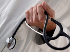 FILE PHOTO: A photo illustration shows a French general practitioner holding a stethoscope in a doctor's office in Bordeaux