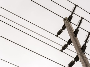 Power lines pass by a hydro utility pole as they are held up by the insulators connecting them to the pole. ALEX FILIPE