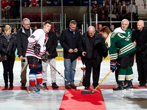 Rev. Kevin Maloney, centre right, and CDSBEO trustee and chair Todd Lalonde, centre left, at the ceremonial puck drop with St. Joseph's Catholic Secondary School Panthers Nolan Shane and Holy Trinity Catholic Secondary School Falcons Drew Hambleton, before the 14th-annual Bishop Cup, on Wednesday March 11, 2020 in Cornwall, Ont. Robert Lefebvre/Special to the Cornwall Standard-Freeholder/Postmedia Network