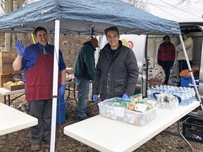 Members of Lionhearts Inc. distribute food and drinks in McBurney Park on March 18. (Steph Crosier/The Whig-Standard)
