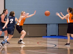 Mayerthorpe Tigers' Autumn Chittick passes back to teammate Alex Jeppesen during a tournament game against a Whitecourt team. The teams faced off Friday morning in the NCJHAA Junior Basketball Championship. Four teams, also including Edson and Evansburg, competed in the competition. 
Brigette Moore | Mayerthorpe Freelancer