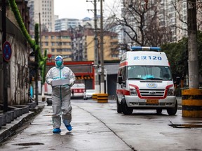 An ambulance worker dressed in protective gear carries supplies to residents in the Chinese city of Wuhan earlier in the pandemic. 
(Image from documentary Inside Wuhan – Life at Ground Zero of the Coronavirus Outbreak)