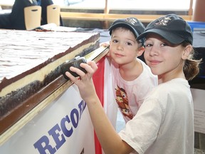 Ella Kurtis, 10, and her brother, Austin, 5, show off their attempt at the Guinness world record for the world's largest Nanaimo bar at Science North on March 6, 2020. The 500-pound bar was on display as part of the science centre's new exhibition, The Science of Guinness World Records.