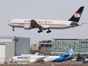 A Cargojet plane lands at the Calgary International Airport on Thursday, March 26, 2020 with a parked WestJet 787 Dreamliner in the background. The COVID-19 pandemic has shut down most passenger air traffic around the world, but the airport has seen an increase in cargo flights. (Gavin Young/Postmedia)